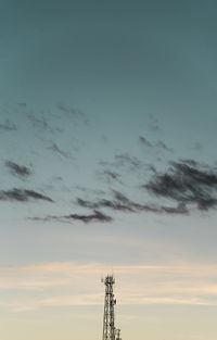 Low angle view of communications tower against sky during sunset