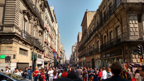 People on street amidst buildings in city