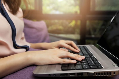 Midsection of woman using laptop