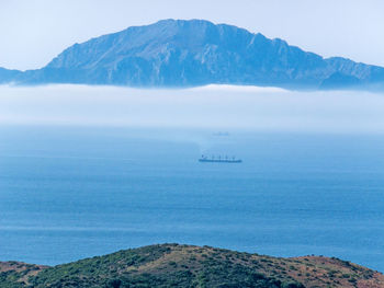 Scenic view of sea and mountains against sky