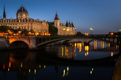 Arch bridge over river at night