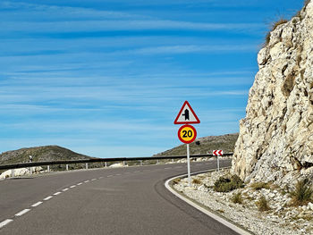 Road sign against sky