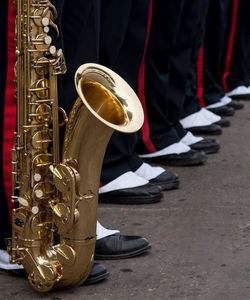 Low section of marching band standing with saxophone on road