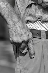 Midsection of man keeping paper currency in pocket