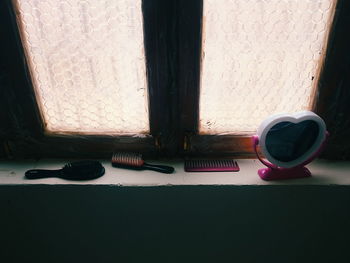 High angle view of combs and mirror on window sill