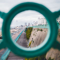 Panoramic view of buildings seen through metal fence