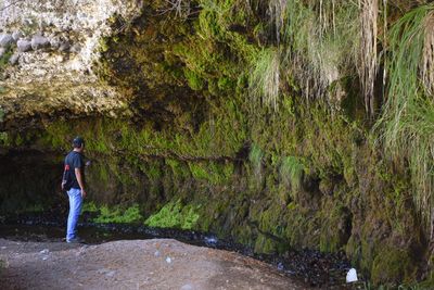 Full length of man standing by rock formation