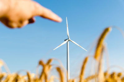 Low angle view of wind turbines against sky