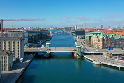 Boats at harbor by city against sky