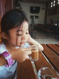 Portrait of a girl drinking glass on table