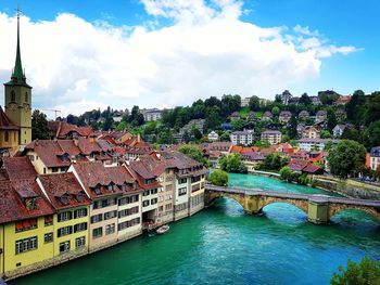 Scenic view of river by city against sky