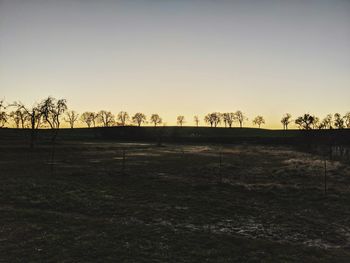 Scenic view of field against clear sky during sunset