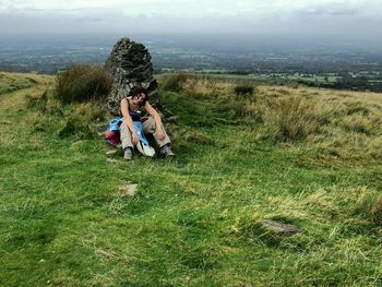 Female hiker sitting on grassy field