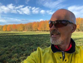 Portrait of man wearing sunglasses on field against sky