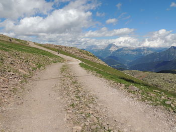 Road leading towards mountains against sky