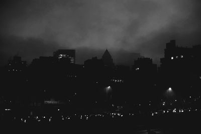 Silhouette buildings against sky at night