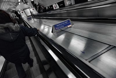 Rear view of man on escalator in subway station