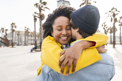 Smiling afro woman hugging man