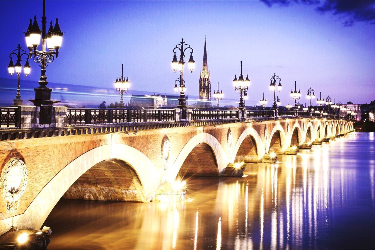 BRIDGE OVER RIVER IN CITY AGAINST SKY