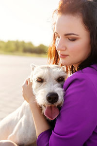 Close-up of young woman embracing dog