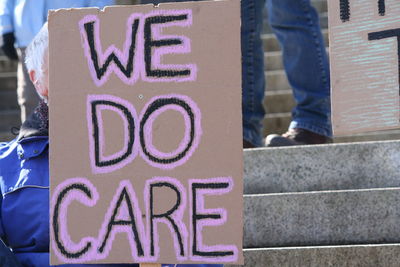 Low section of man with sign