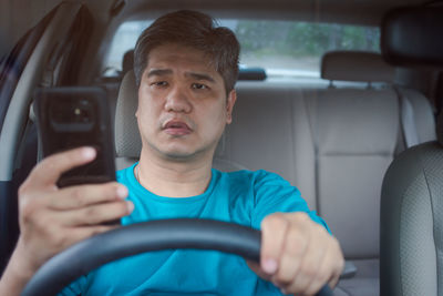 Portrait of man sitting in car