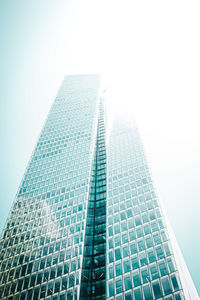 Directly below shot of modern glass building against clear sky