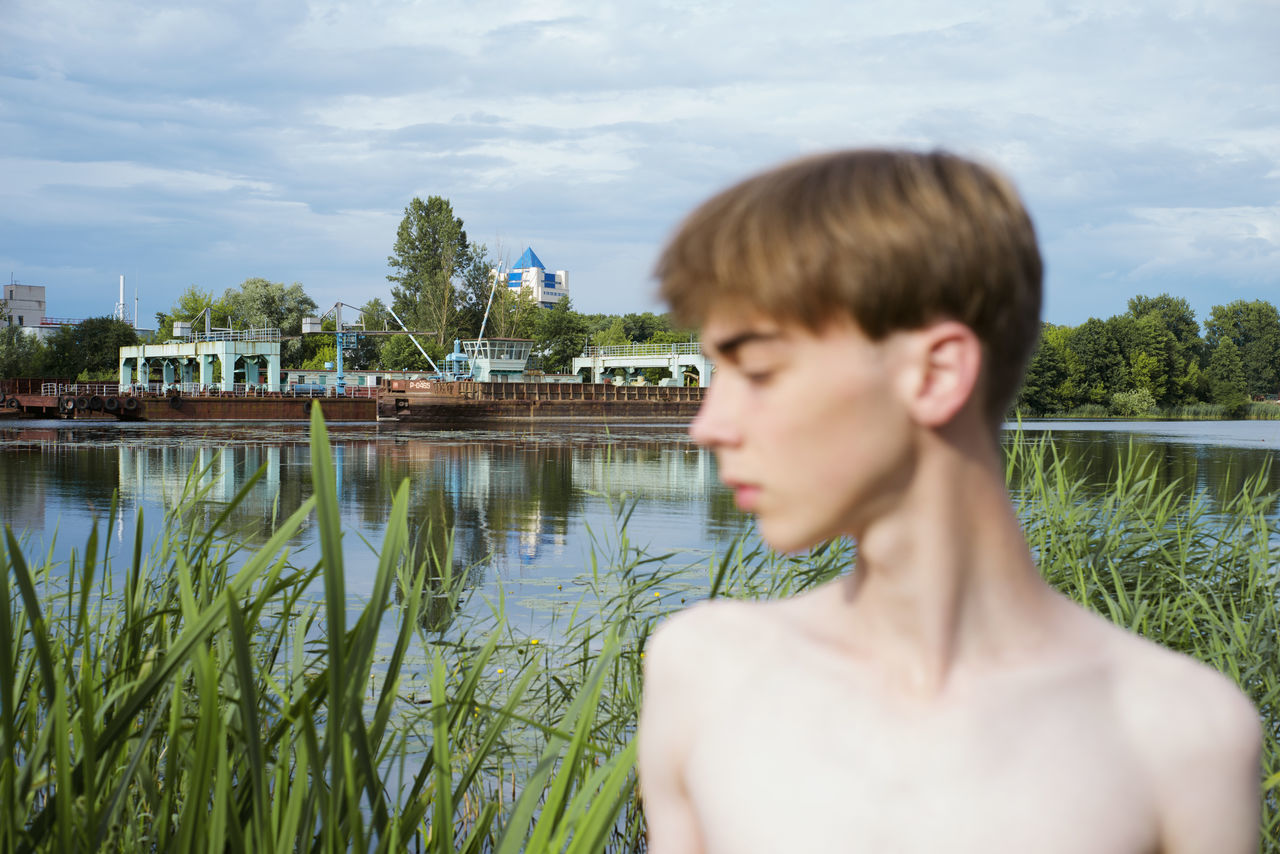 PORTRAIT OF SENIOR MAN AGAINST LAKE