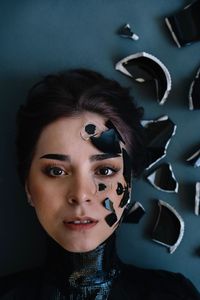 Portrait of beautiful young woman with broken glass on face