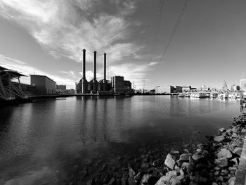 River by buildings against sky