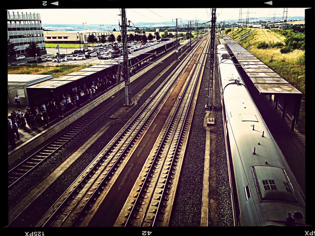 transfer print, railroad track, auto post production filter, transportation, built structure, architecture, rail transportation, city, diminishing perspective, the way forward, high angle view, building exterior, vanishing point, railroad station platform, railroad station, public transportation, incidental people, city life, day, connection