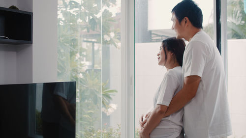 Young couple standing in window