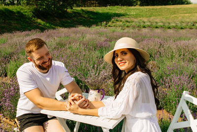 Close up of happy couple sitting near table  in lavender field 