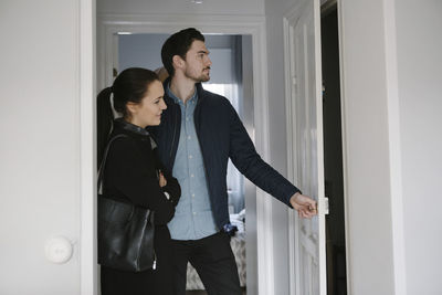 Side view of young couple looking at entrance