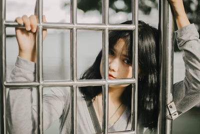 Portrait of woman looking through window