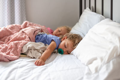 Cute kids sleeping on bed