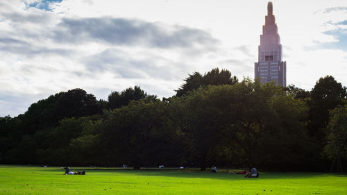 People on building against cloudy sky