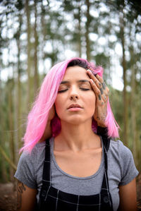 Young woman receiving head massage in forest