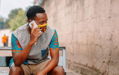 Midsection of man sitting against wall