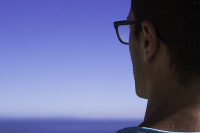 Close-up of young man against clear sky