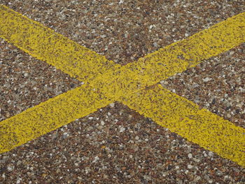 High angle view of yellow arrow sign on road