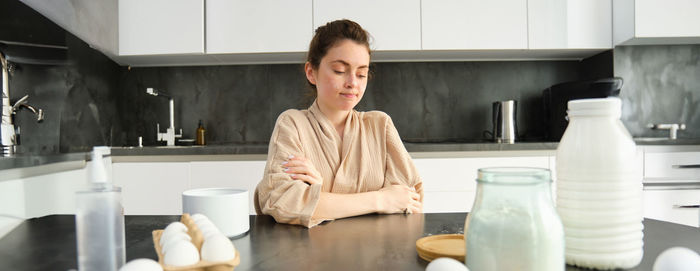 Portrait of young woman using mobile phone on table