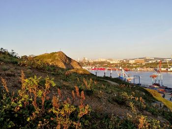 Scenic view of sea and buildings against clear sky