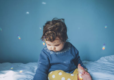 Cute baby girl on bed at home