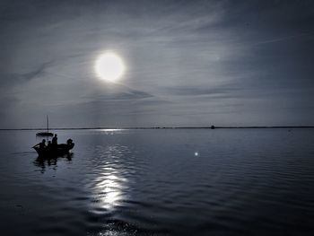 Silhouette boat in sea against sky