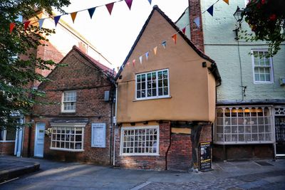 Houses by street against sky