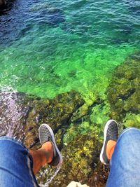 Low section of person on rock by sea