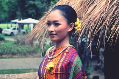 Young woman in traditional clothing standing outdoors