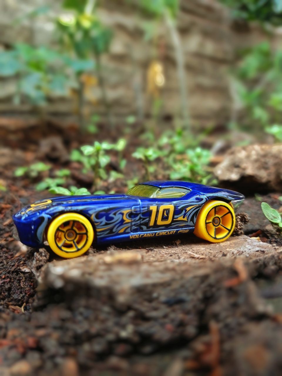 CLOSE-UP OF TOY CAR ON ROCK