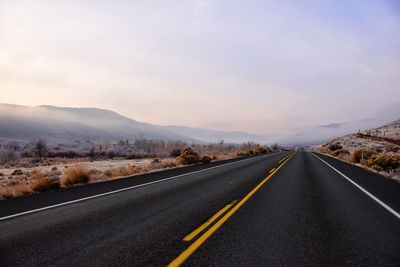 Empty road by mountain against sky